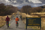 Cyclists on Otago Rail Trail near Oturehua, Central Otago Cyclists on Otago Rail Trail near Oturehua, gathering snow storm, Central Otago, New Zealand.