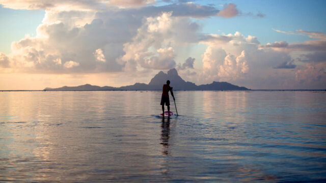 Paddle boarding in the lagoon at Le Taha'a Resort and Spa, French Polynesia.