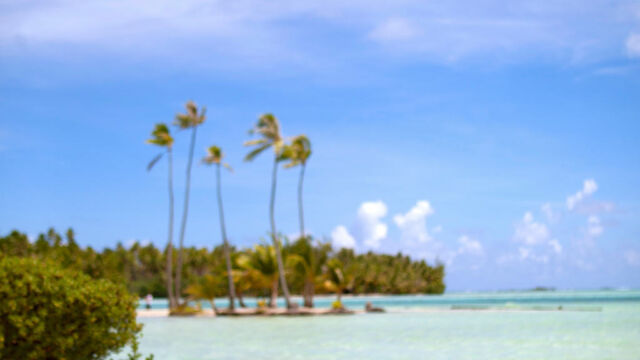 Lounge chairs on beach with view of lagoon at Le Taha'a resort, French Polynesia
